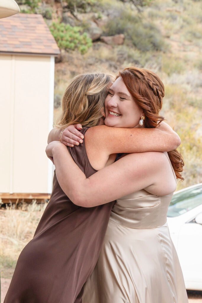 Ash smiles as she shares a warm hug with a loved one before the wedding ceremony.