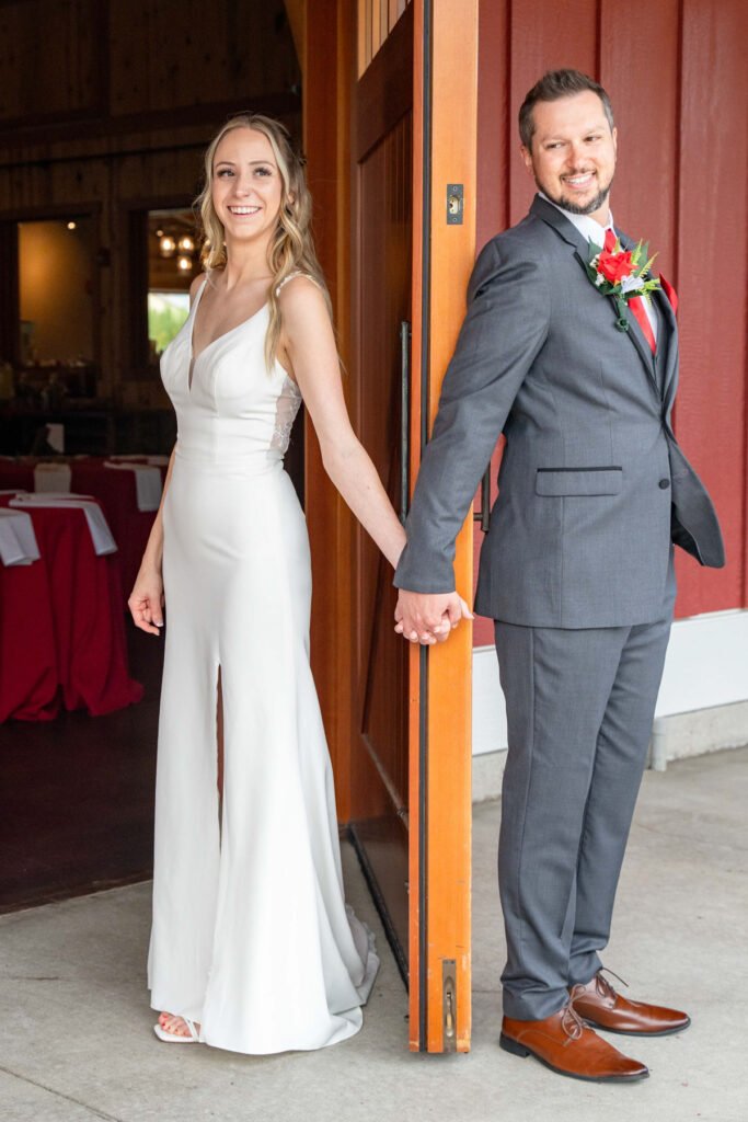 Leslie and Michael hold hands around a doorway before the ceremony.