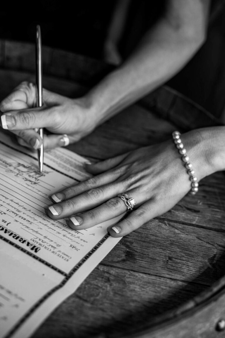Black and white close-up of Leslie signing the marriage license.